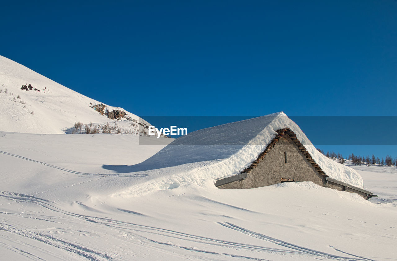 Scenic view of snowcapped mountain against clear blue sky