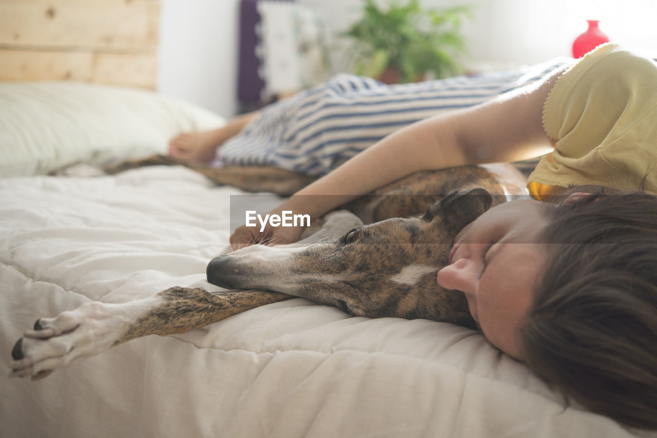 Woman with dog sleeping on bed