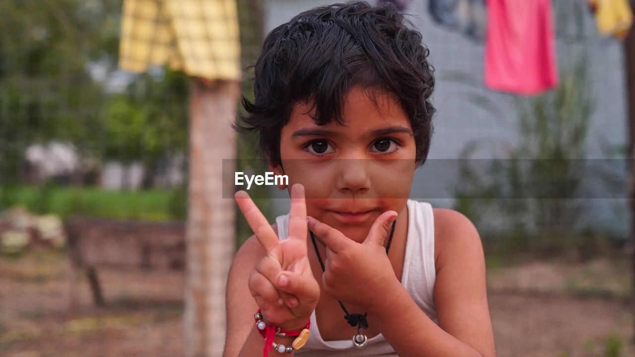 Smart kid making v with fingers. portrait of smiling kid showing victory sign with fingers of hand.
