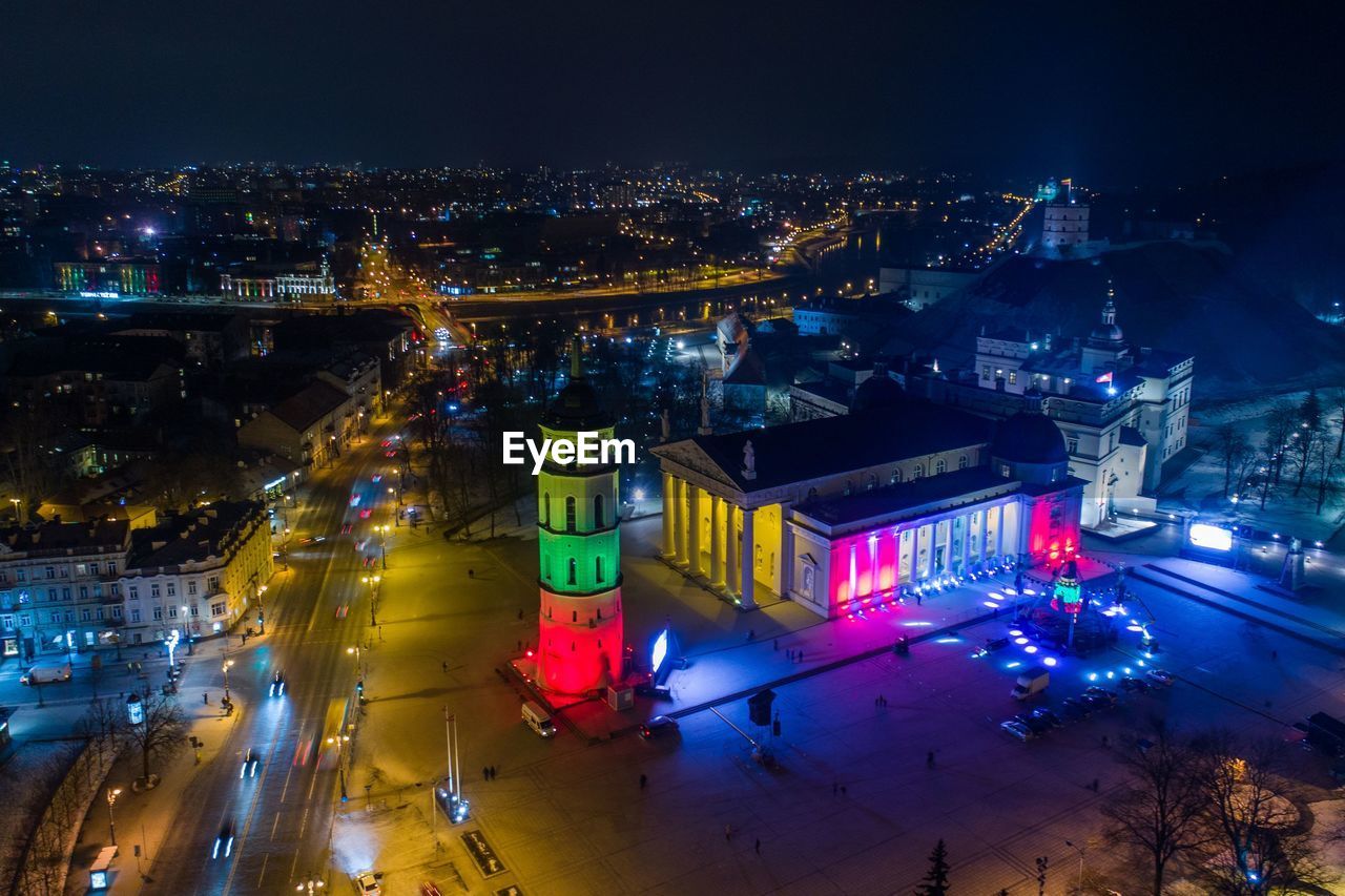 HIGH ANGLE VIEW OF ILLUMINATED CITY BUILDINGS AT NIGHT