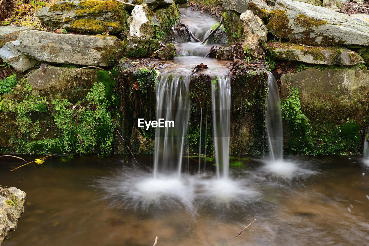 WATER FLOWING THROUGH ROCKS ON ROCK FORMATION