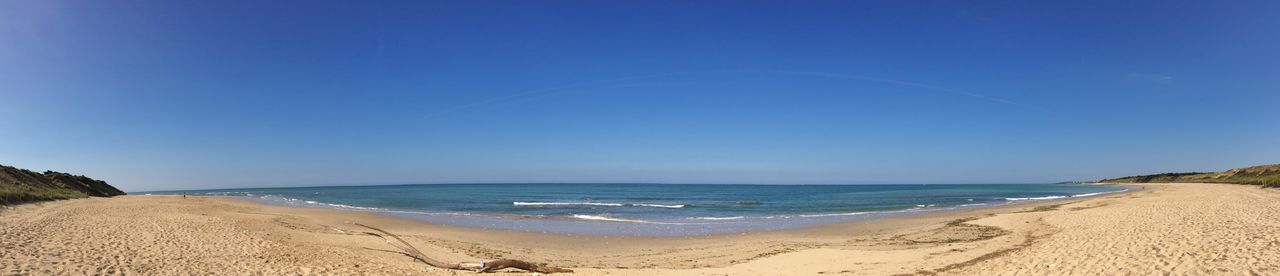 Scenic view of beach against blue sky