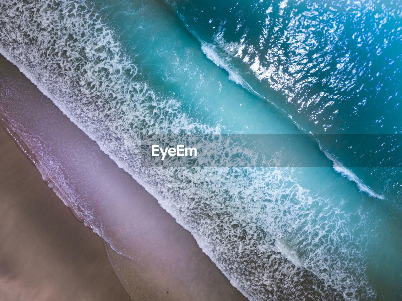 HIGH ANGLE VIEW OF ICE ON BEACH