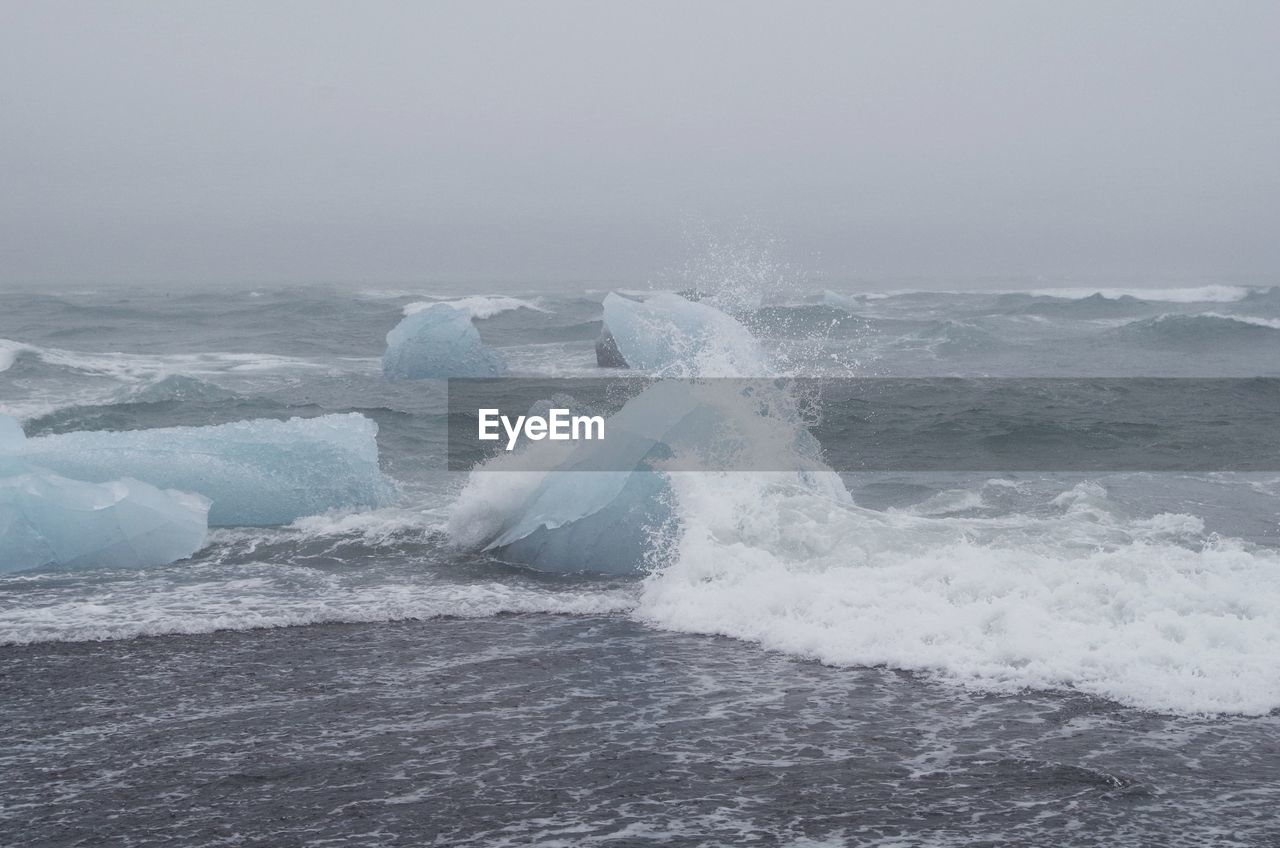 Iceberg in sea against sky