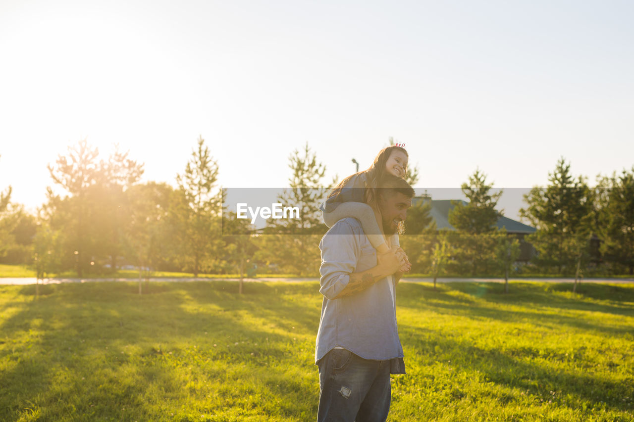 MAN STANDING IN FIELD AGAINST SKY