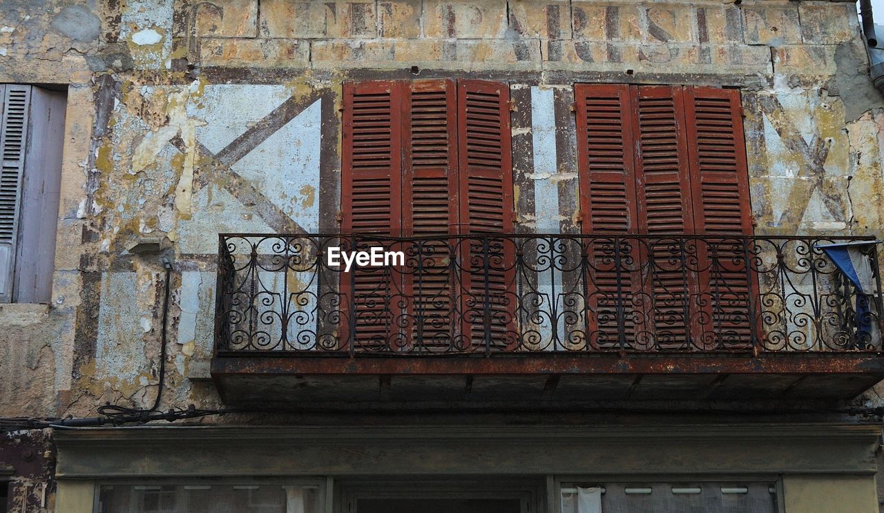 Low angle view of balcony at old damaged building