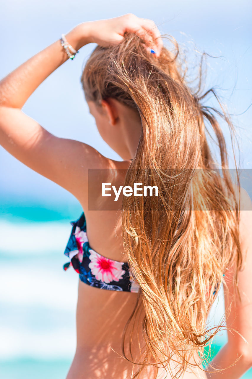 rear view of young woman in bikini against sky