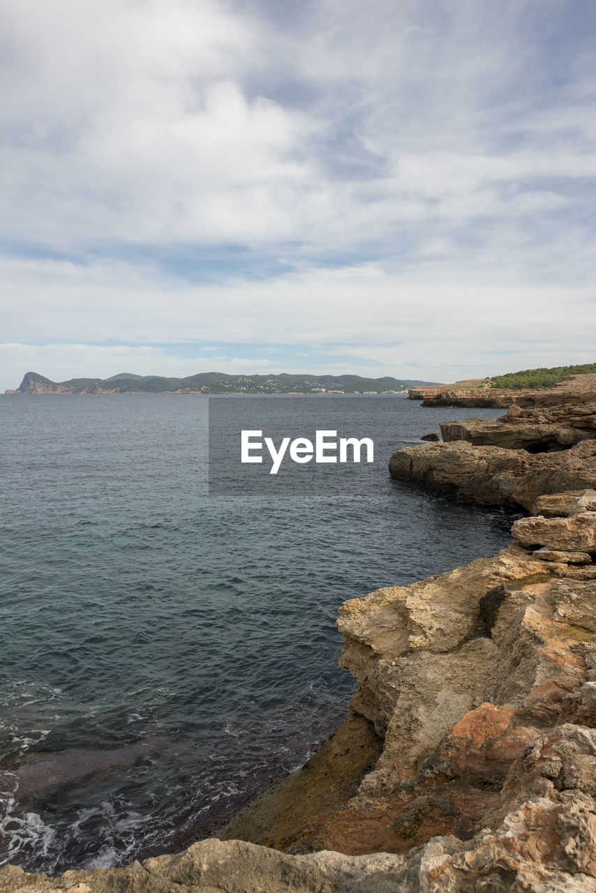 ROCK FORMATIONS ON SEA AGAINST SKY