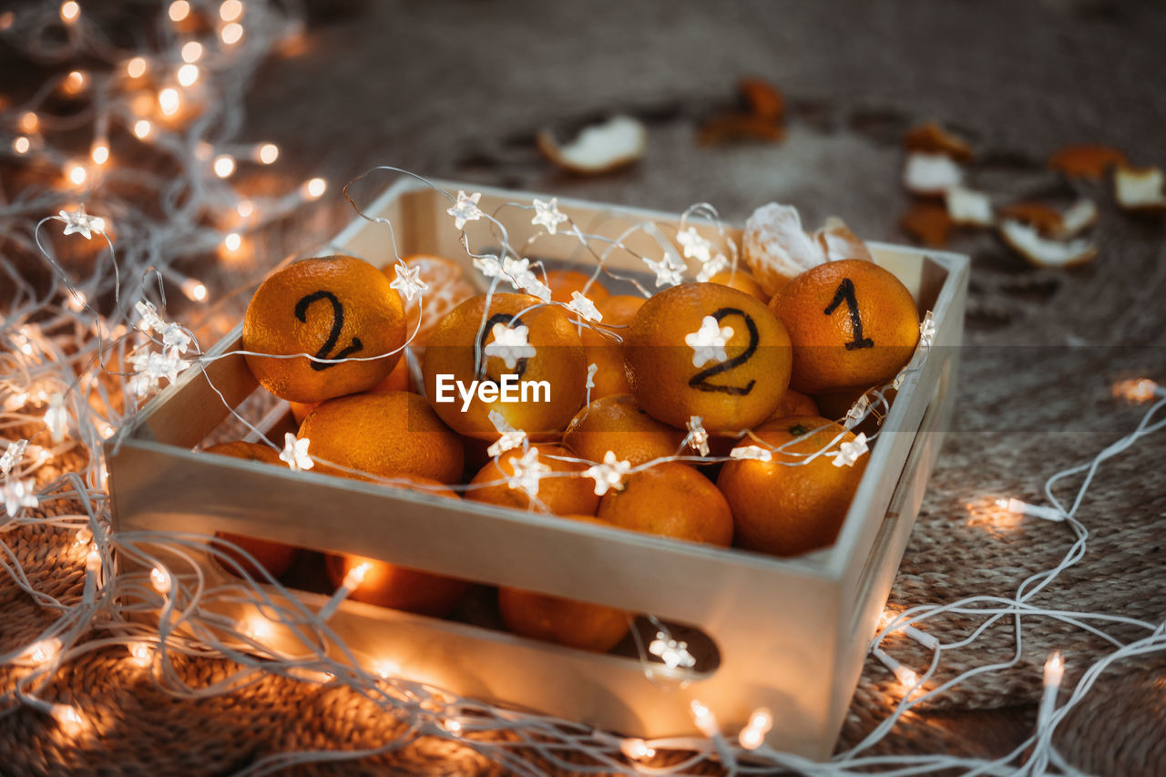 Christmas greeting  new year 2021 is coming, cozy christmas. black numbers 2021 written on oranges.