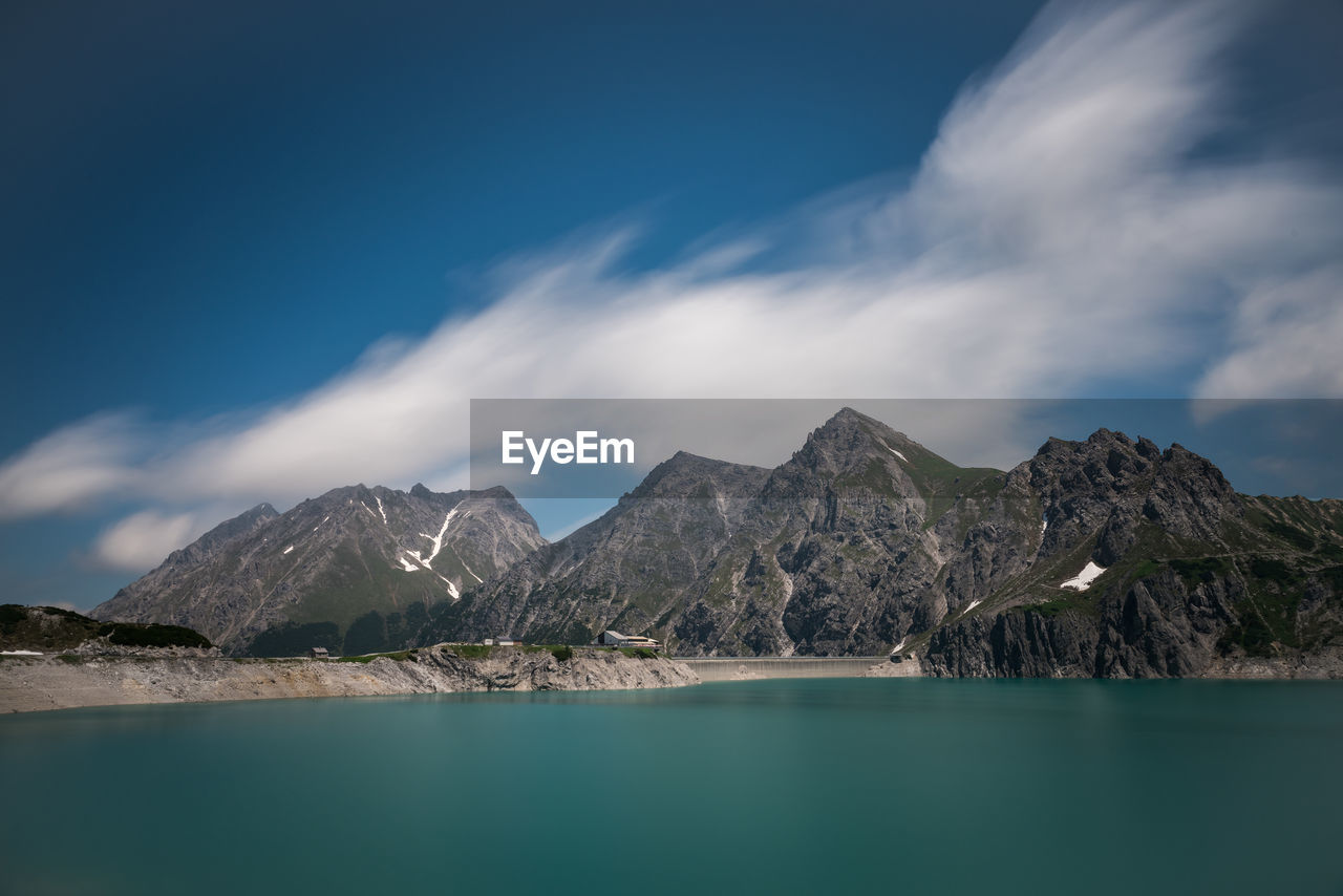 Scenic view of sea and mountains against sky