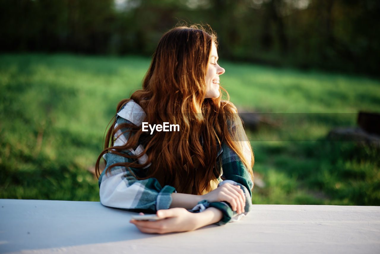 rear view of woman using mobile phone in park