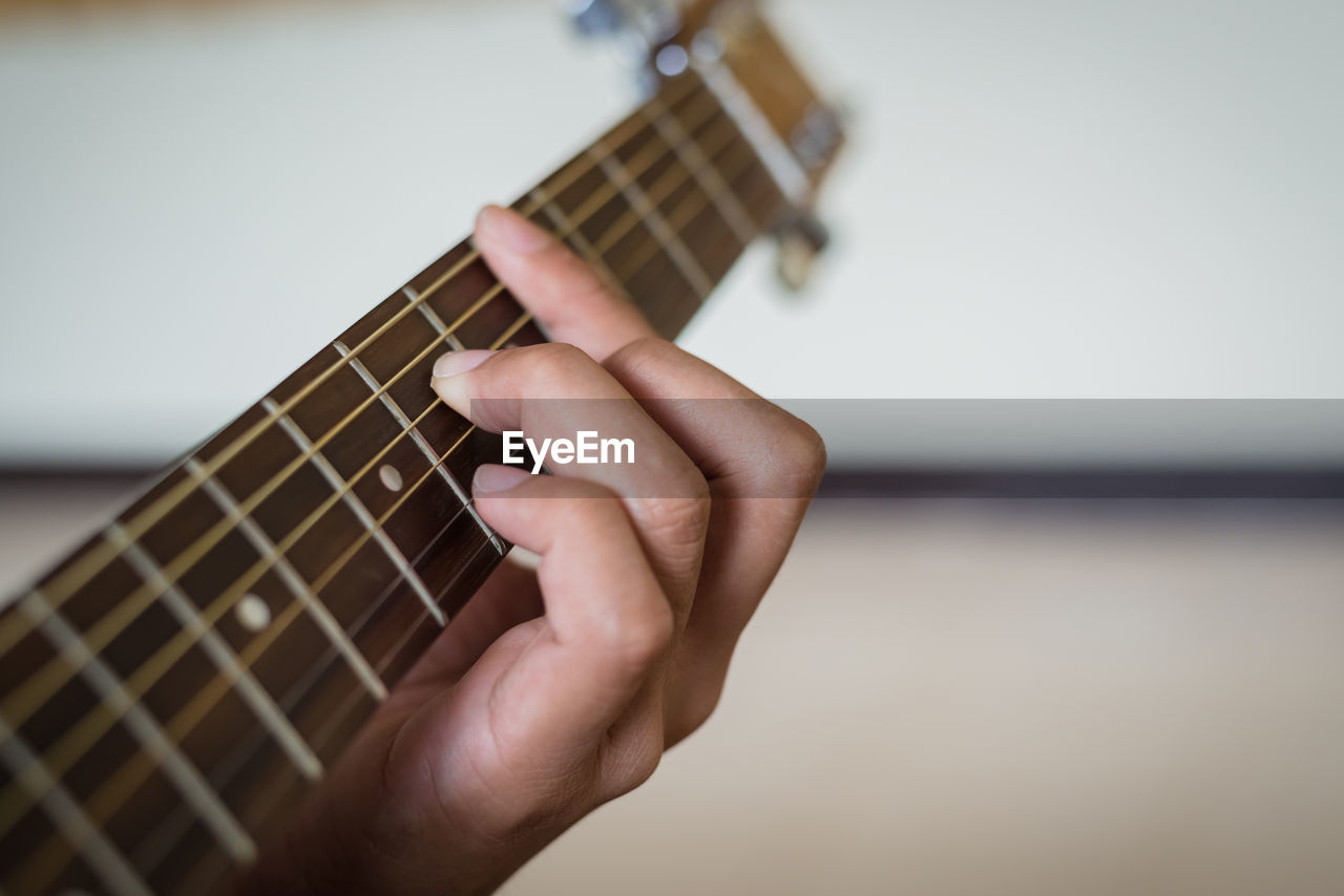 Cropped image of person playing guitar