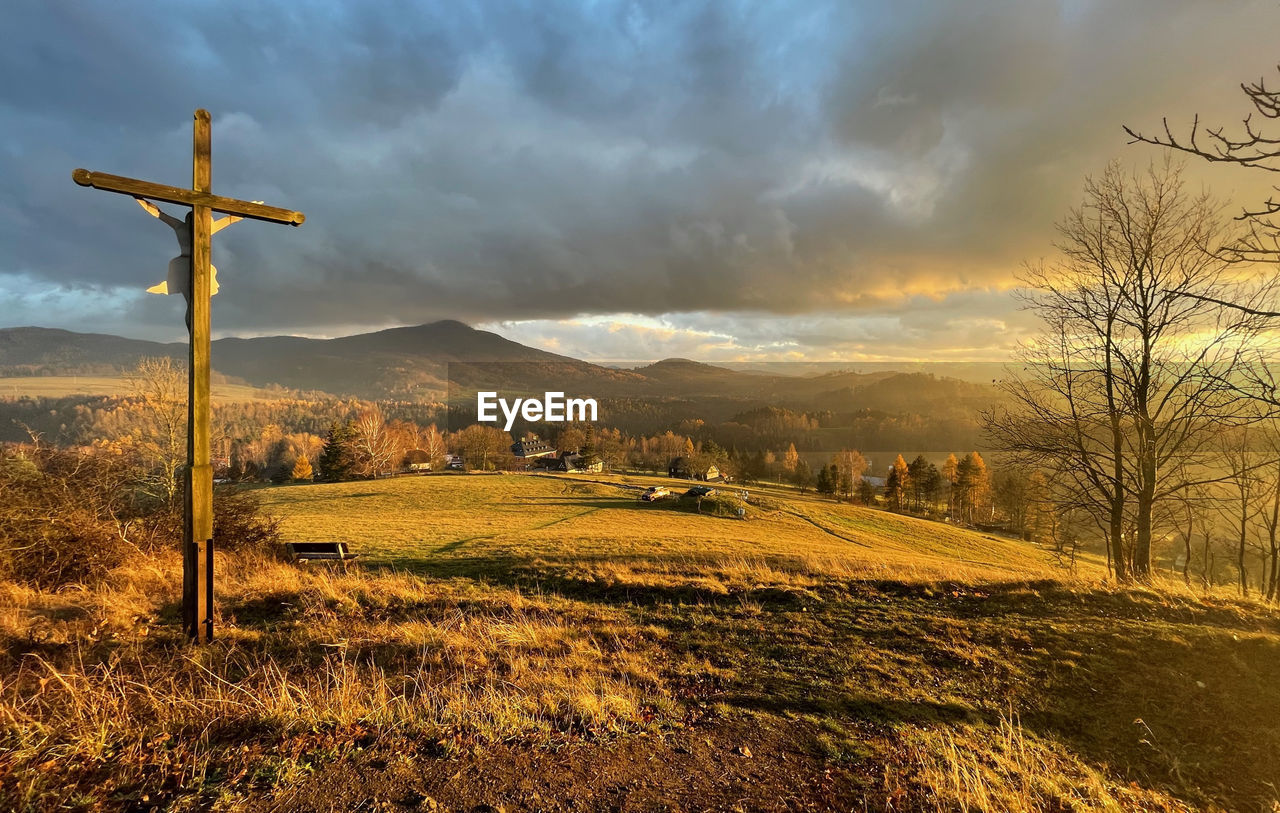 WINDMILL ON FIELD AGAINST SKY DURING SUNSET