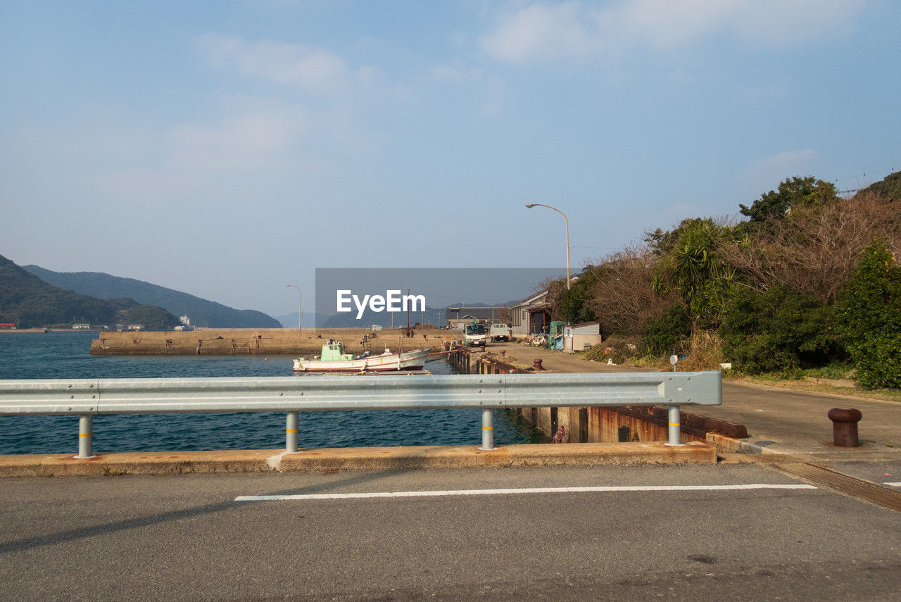 water, sky, sea, coast, mountain, nature, transportation, architecture, vacation, land, shore, road, beach, built structure, no people, travel destinations, day, tree, city, travel, scenics - nature, walkway, street, cloud, building exterior, outdoors, beauty in nature, bay, tourism, tranquility, plant, building, coastline, body of water, environment, boardwalk, tranquil scene