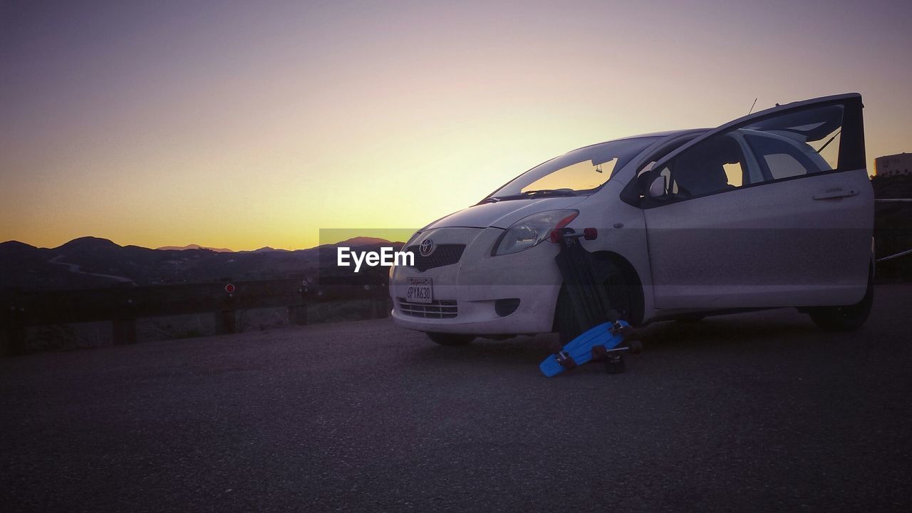 CARS PARKED ON ROAD AGAINST MOUNTAIN