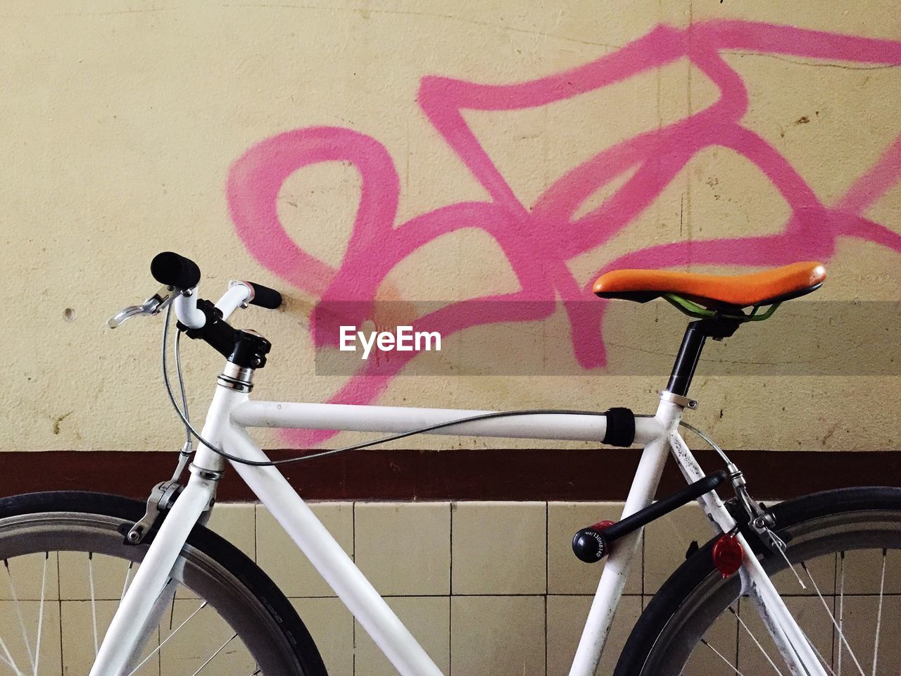 Bicycle parked against wall outdoors