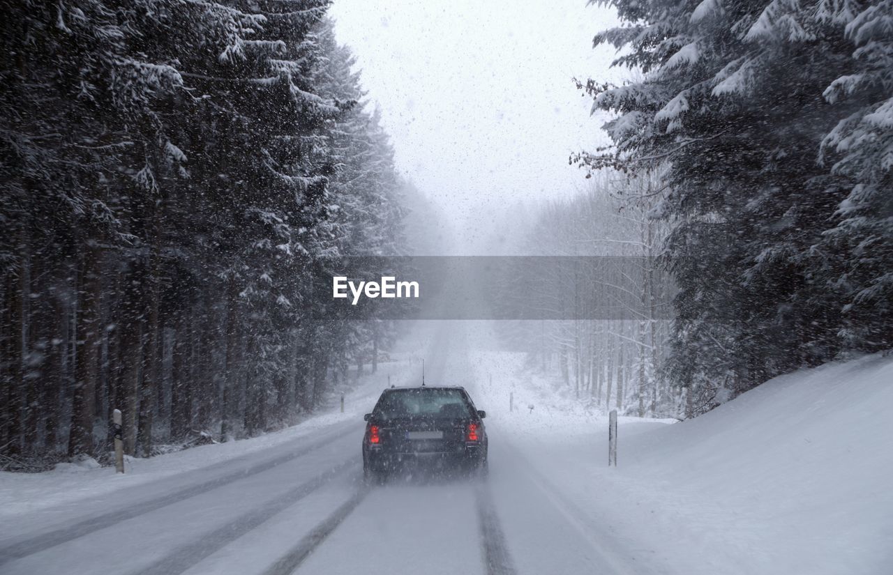 CAR ON SNOW COVERED ROAD