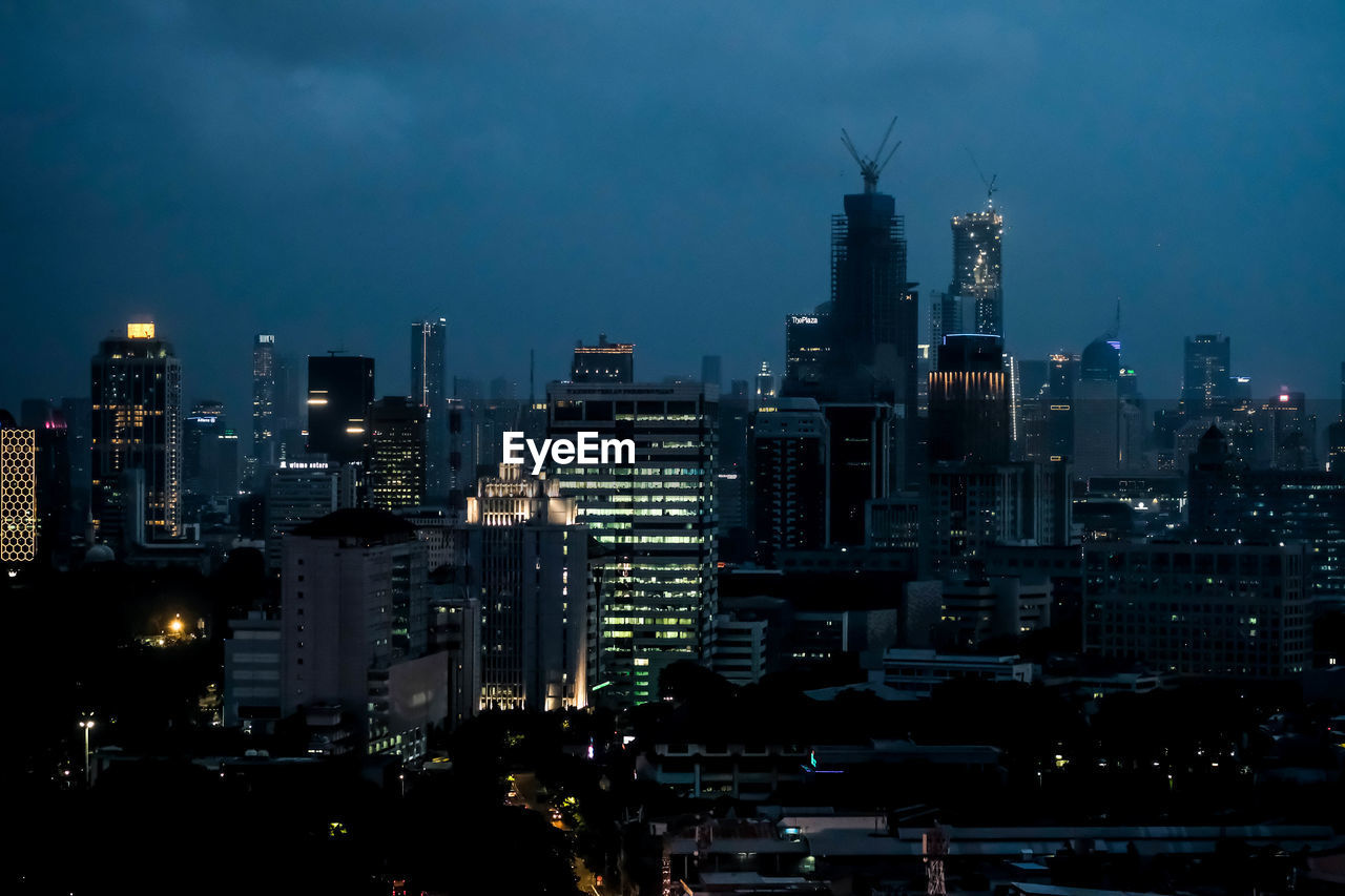 Illuminated cityscape against sky at night