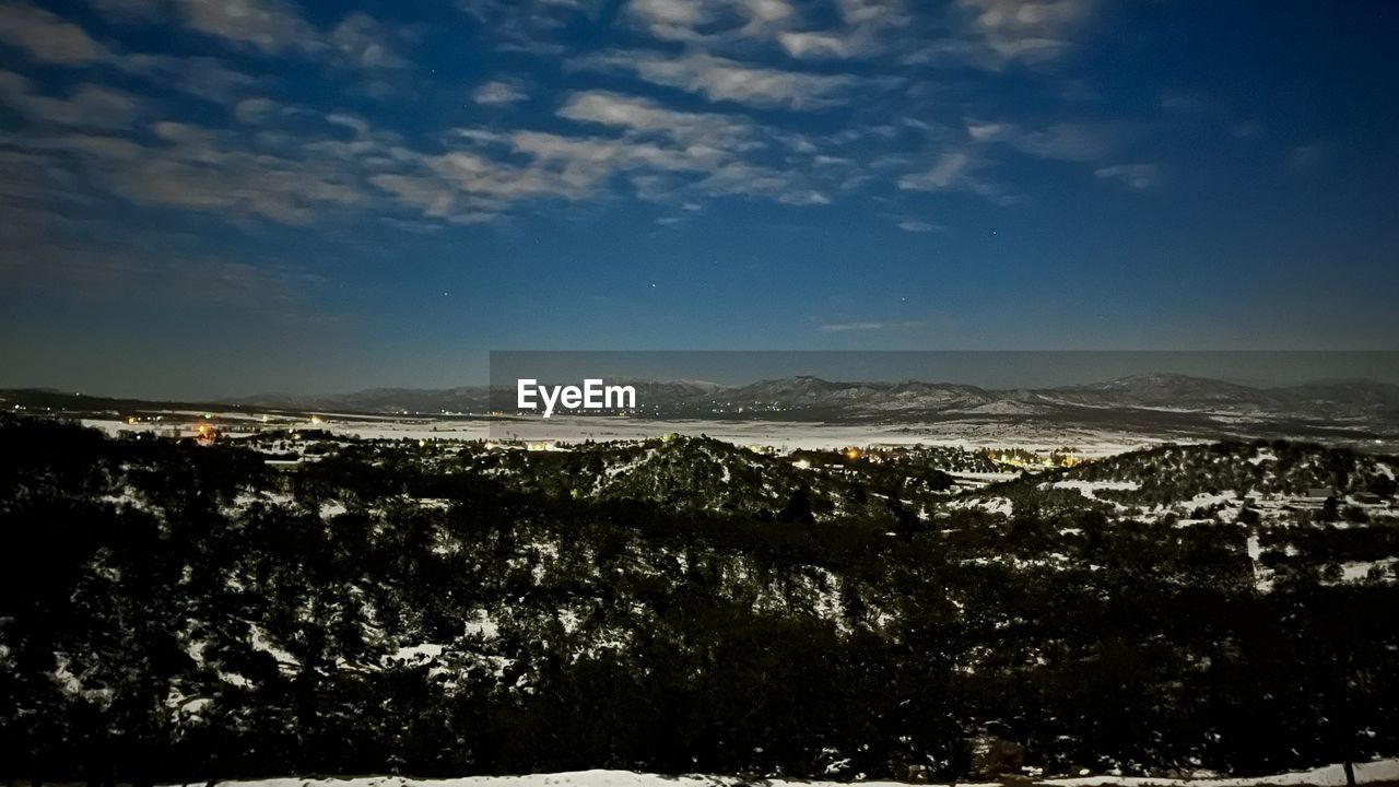 SCENIC VIEW OF ILLUMINATED MOUNTAINS AGAINST SKY AT NIGHT