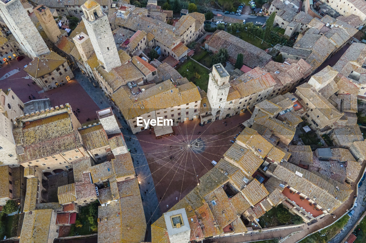 Aerial view of san gimignano town square with christmas lights at sunset, siena, tuscany, italy.