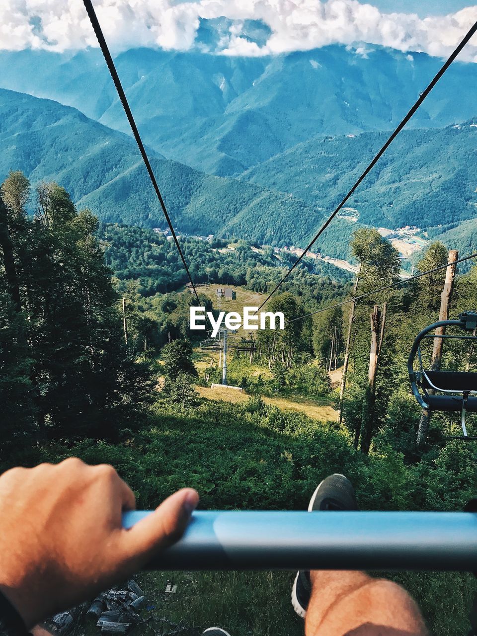 Cropped hand of person sitting on cable car