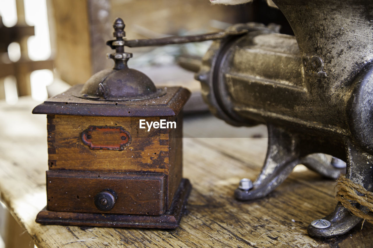 Close-up of old coffee grinder on table