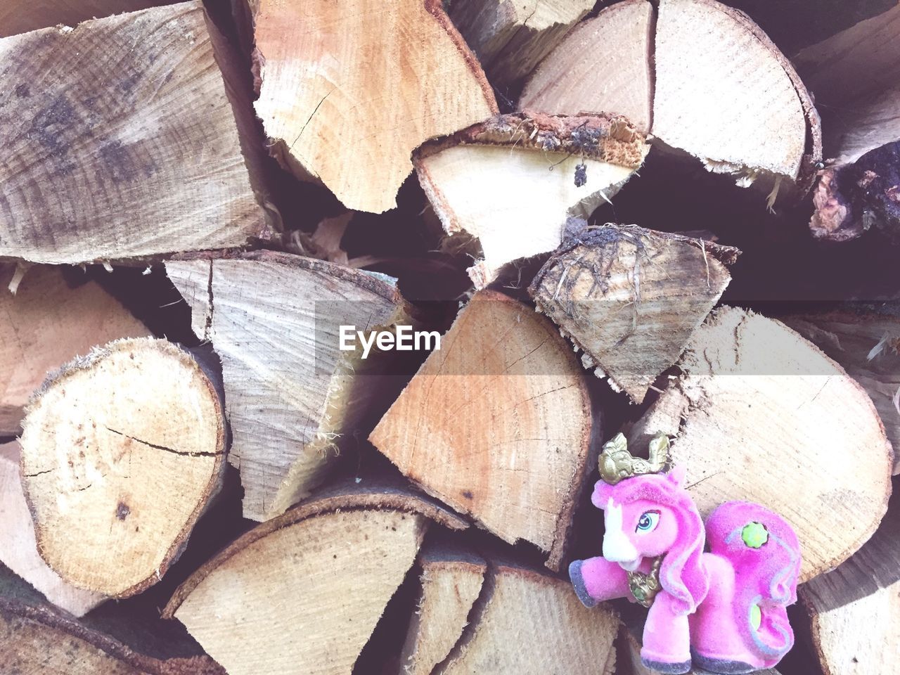 Pink stuffed toy against logs