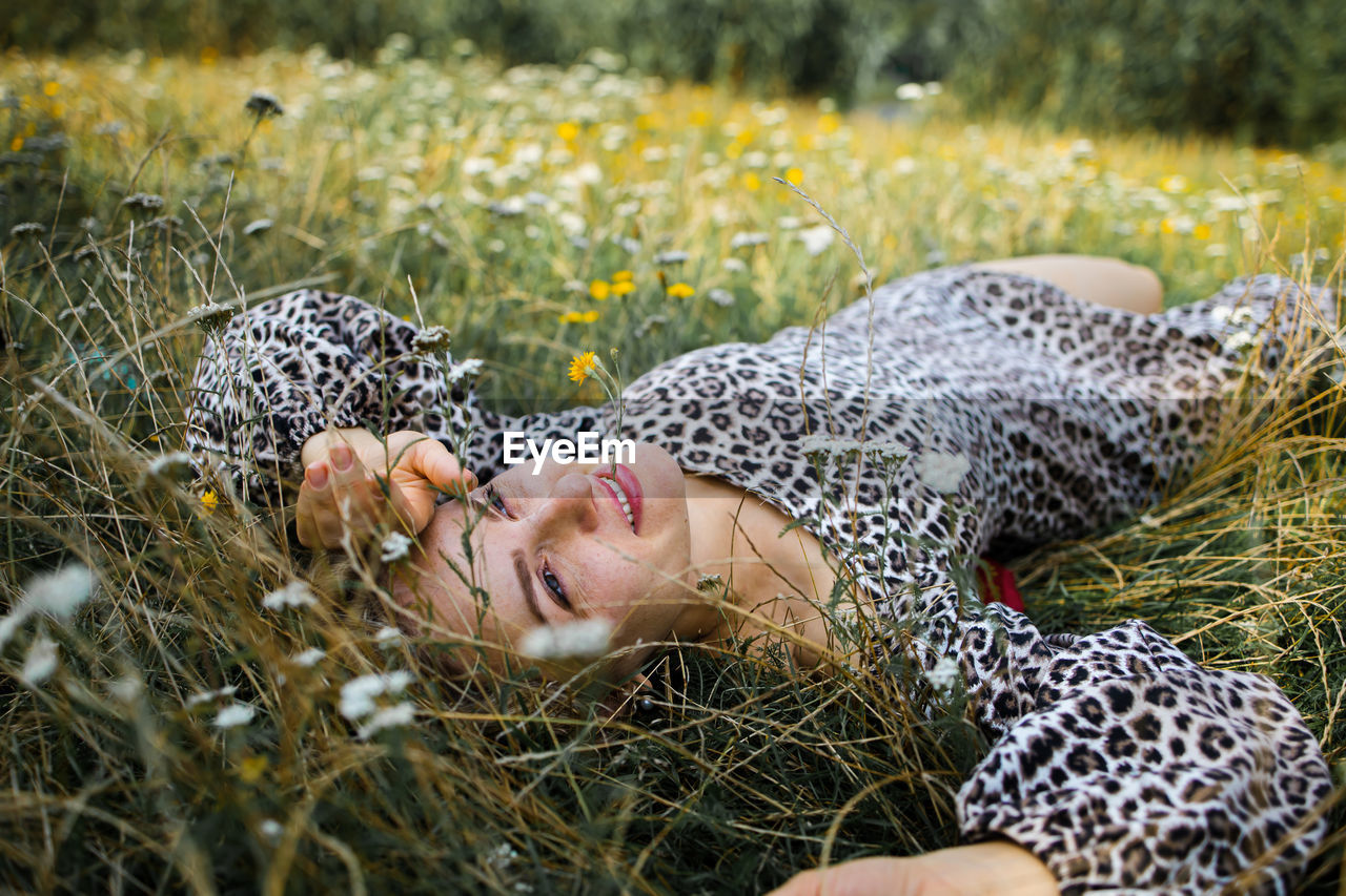 Summer lifestyle portrait middle aged woman lying on the grass 