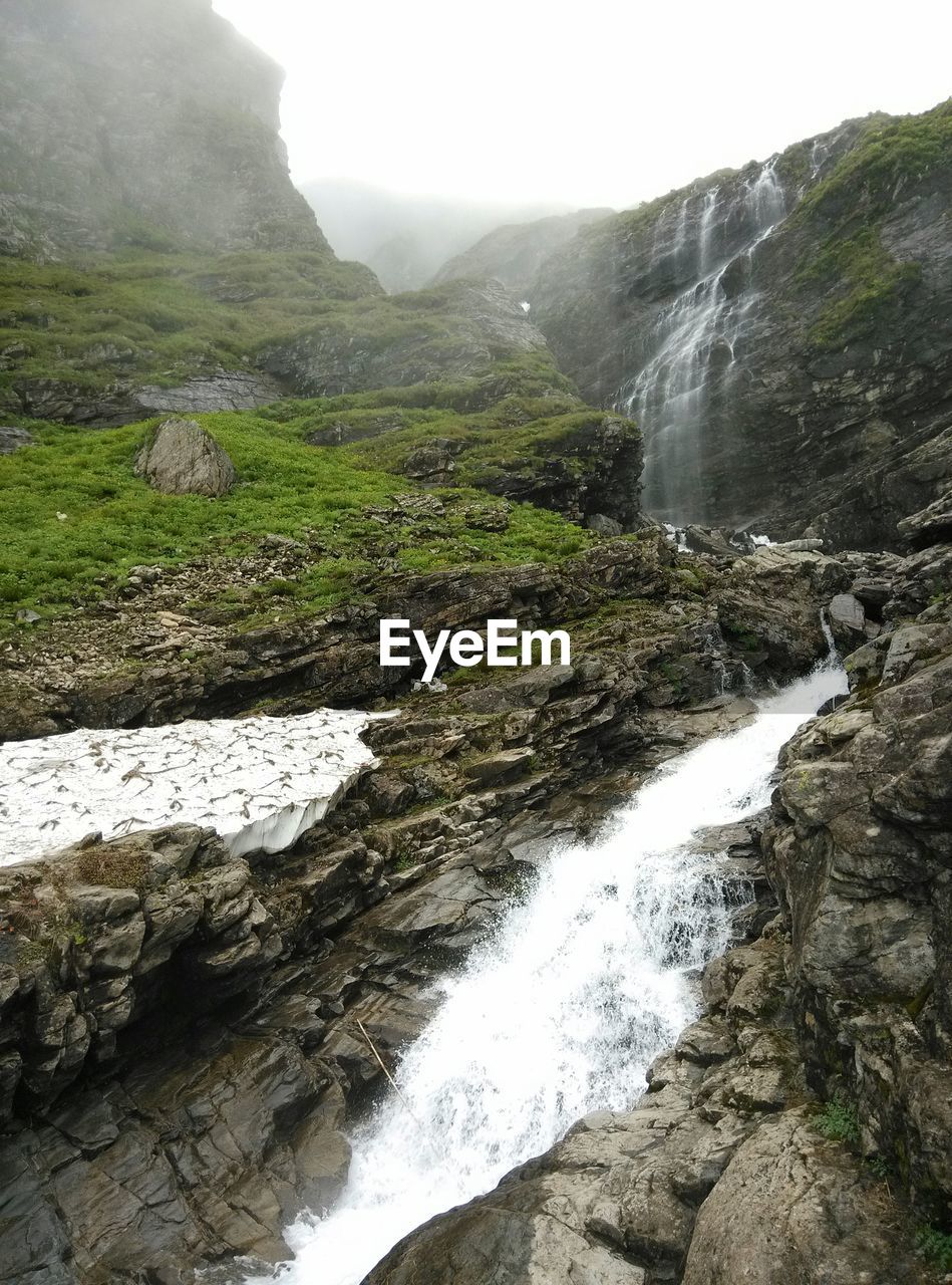 Low angle view of waterfall in mountain