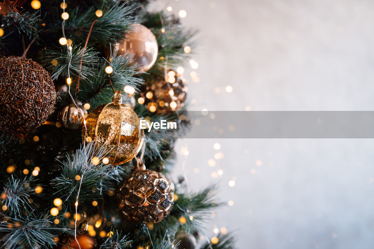 Christmas tree with golden decoration and bokeh.