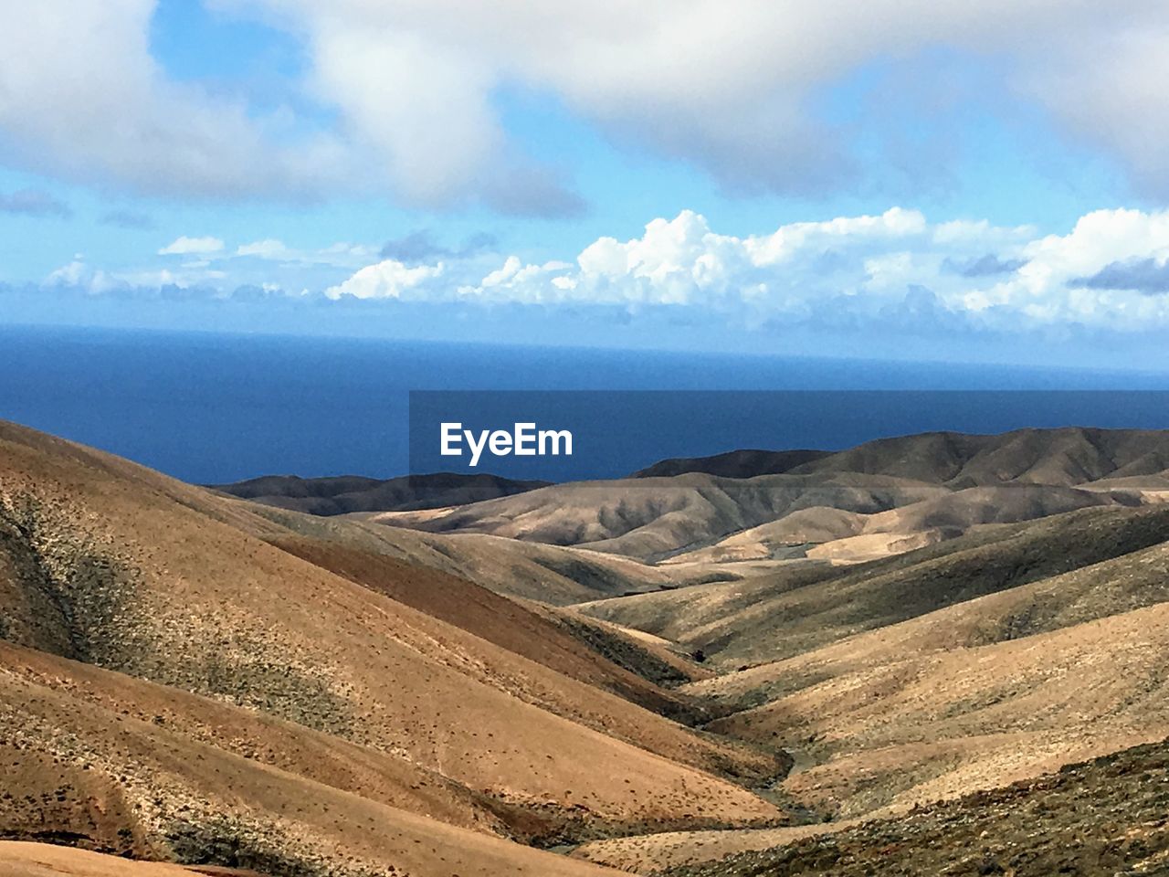 Scenic view of sea and mountains against sky