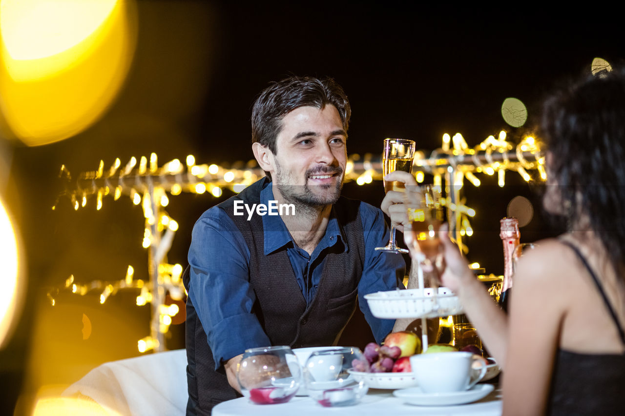 Young couple having drinks at table on terrace