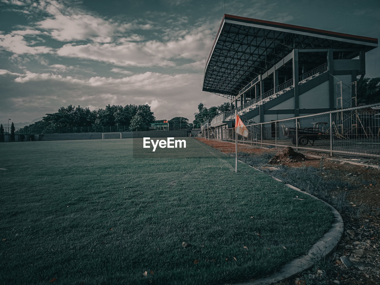 View of building by field against sky