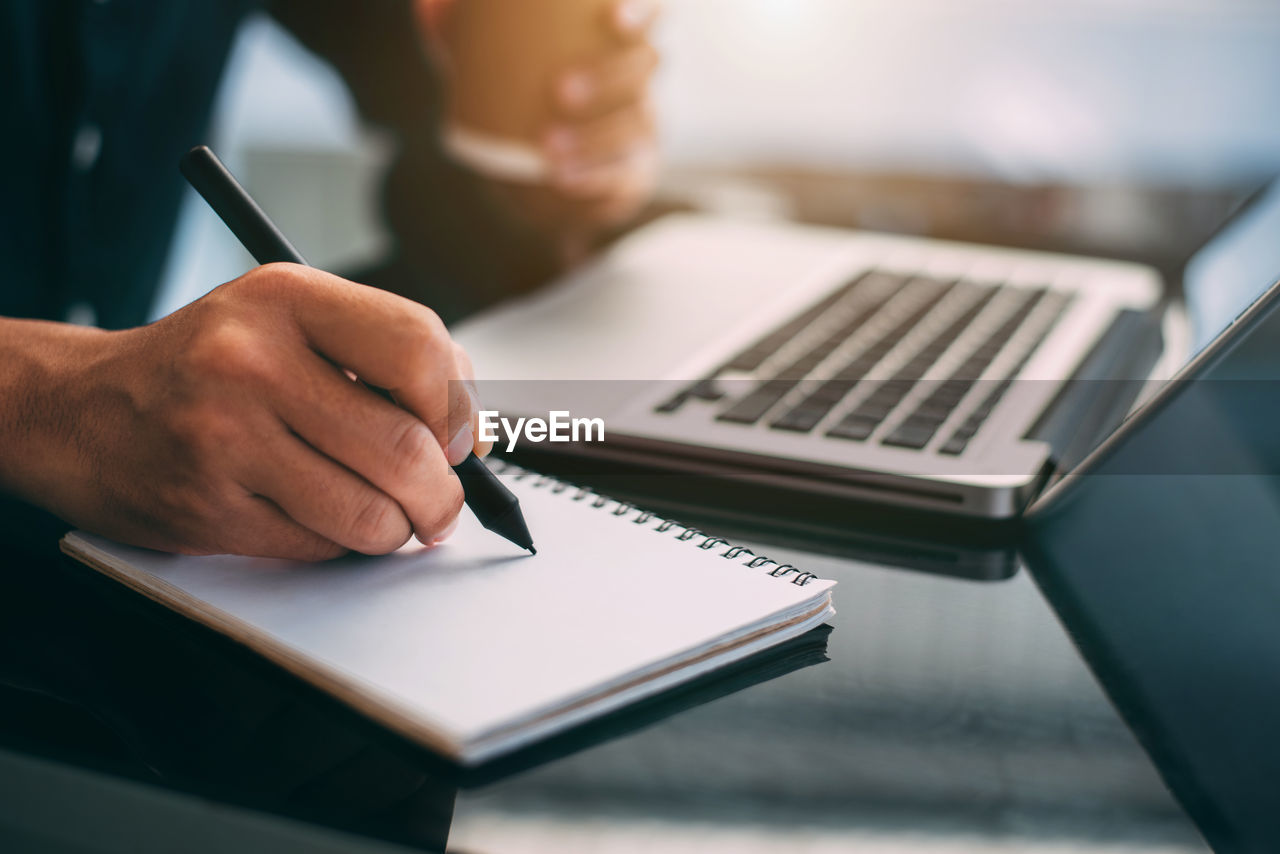 midsection of woman using laptop at table