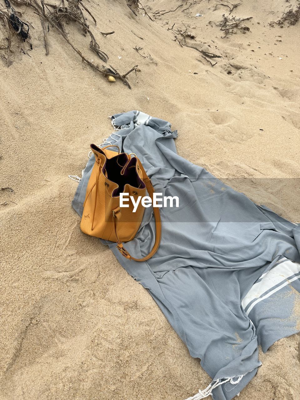 sand, land, beach, high angle view, nature, vacation, shoe, trip, sunlight, day, holiday, relaxation, clothing, summer, leisure activity, outdoors, one person, casual clothing, travel, lying down