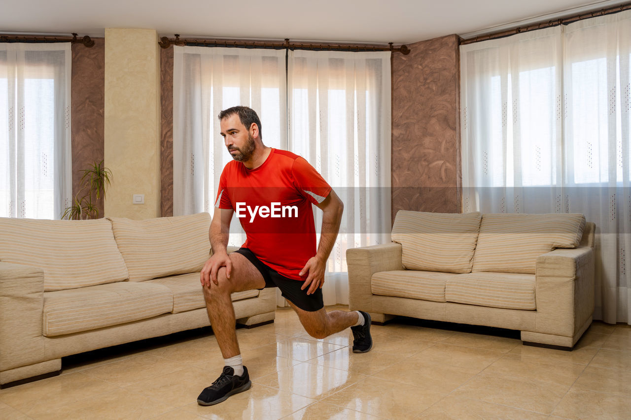 FULL LENGTH OF MAN SITTING ON SOFA