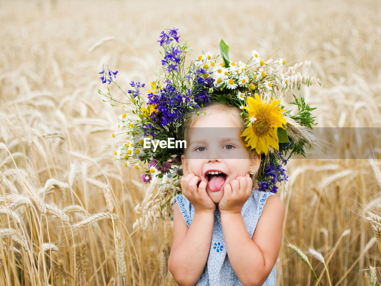 Portrait of girl wearing flowers on hair at field