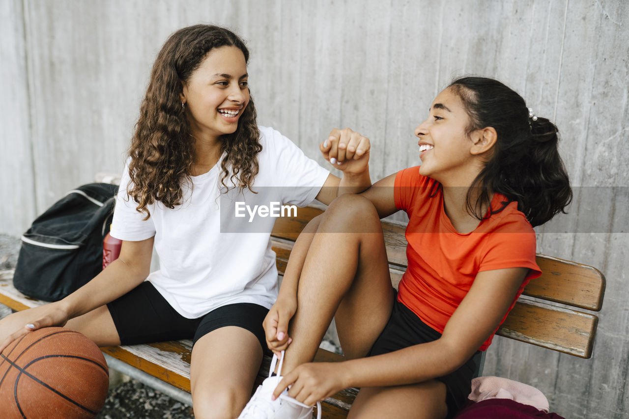 Happy girls spending leisure time at basketball court