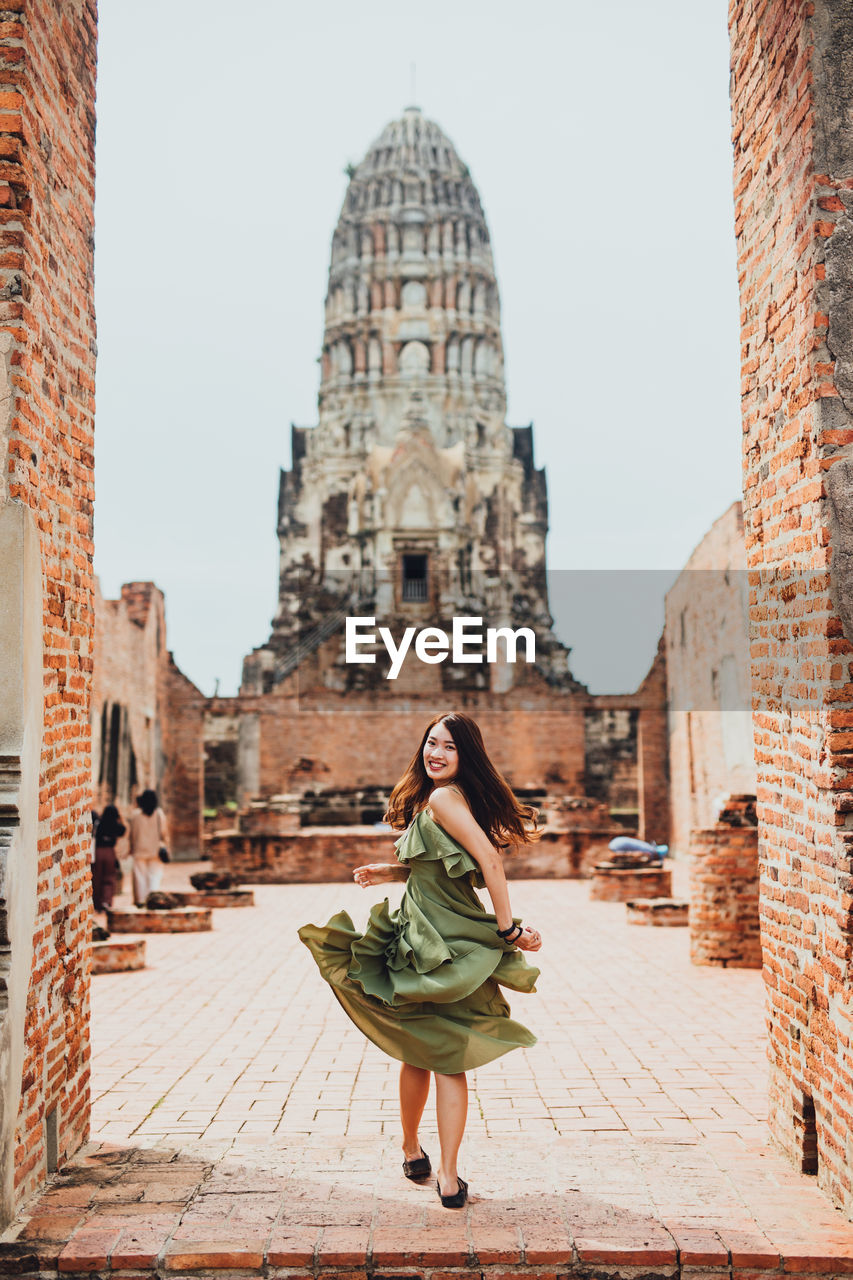 Tourist woman in green dress at wat ratchaburana temple, ayutthaya, thailand