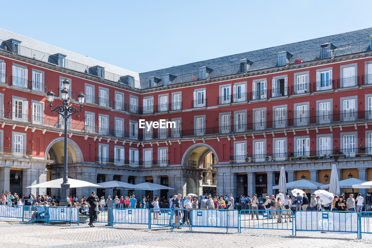 PEOPLE IN TOWN SQUARE AGAINST CLEAR SKY