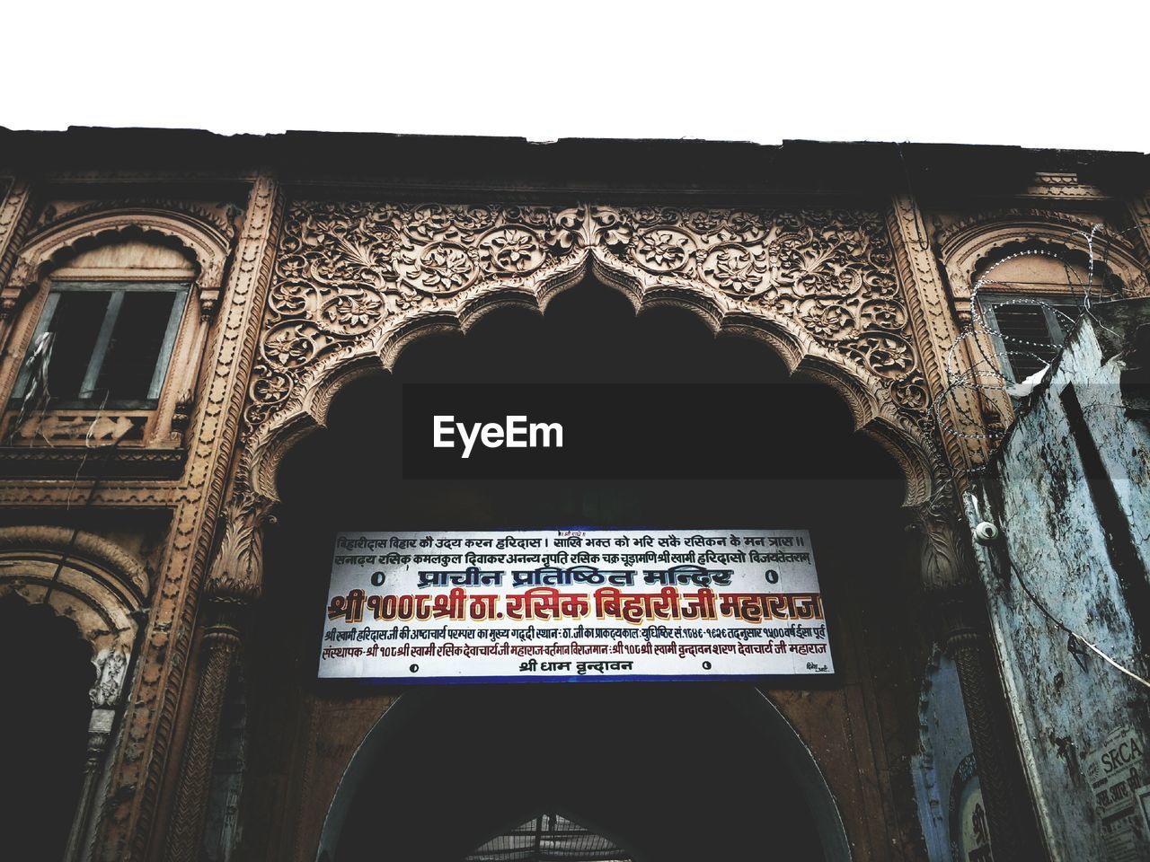 LOW ANGLE VIEW OF INFORMATION SIGN AGAINST TEMPLE