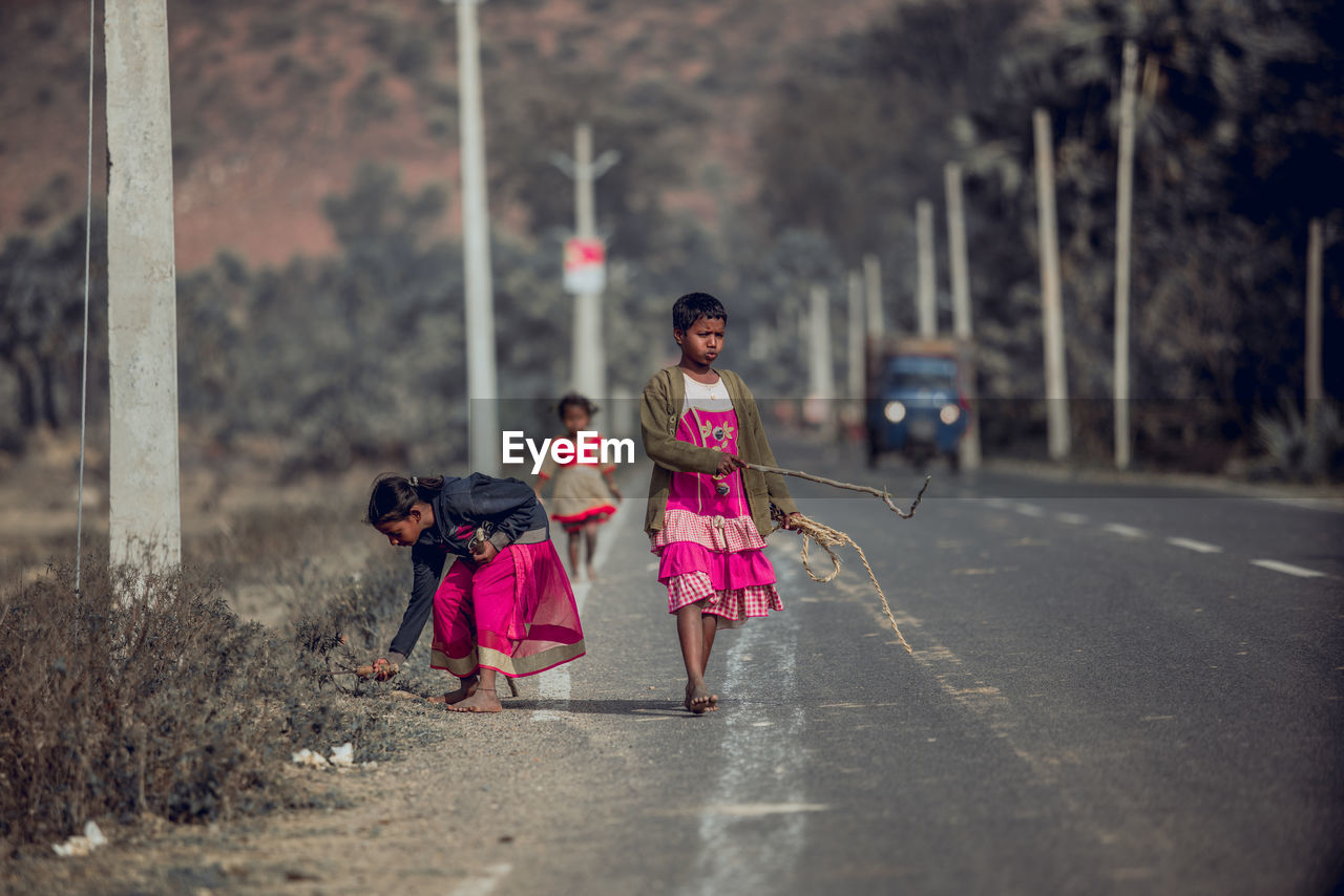 REAR VIEW OF WOMEN WITH PINK WALKING ON STREET