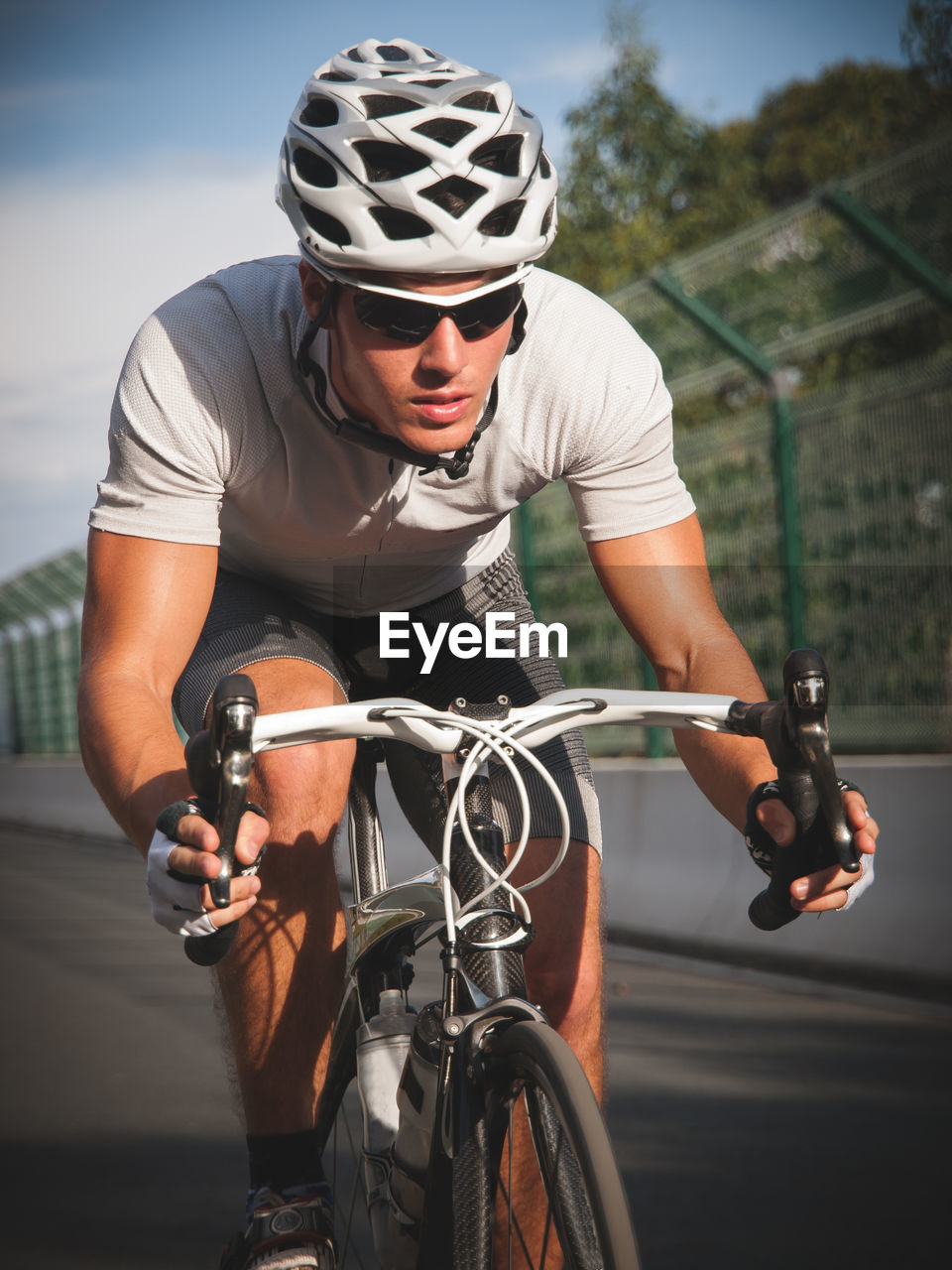 Full length of man riding bicycle on road by railing