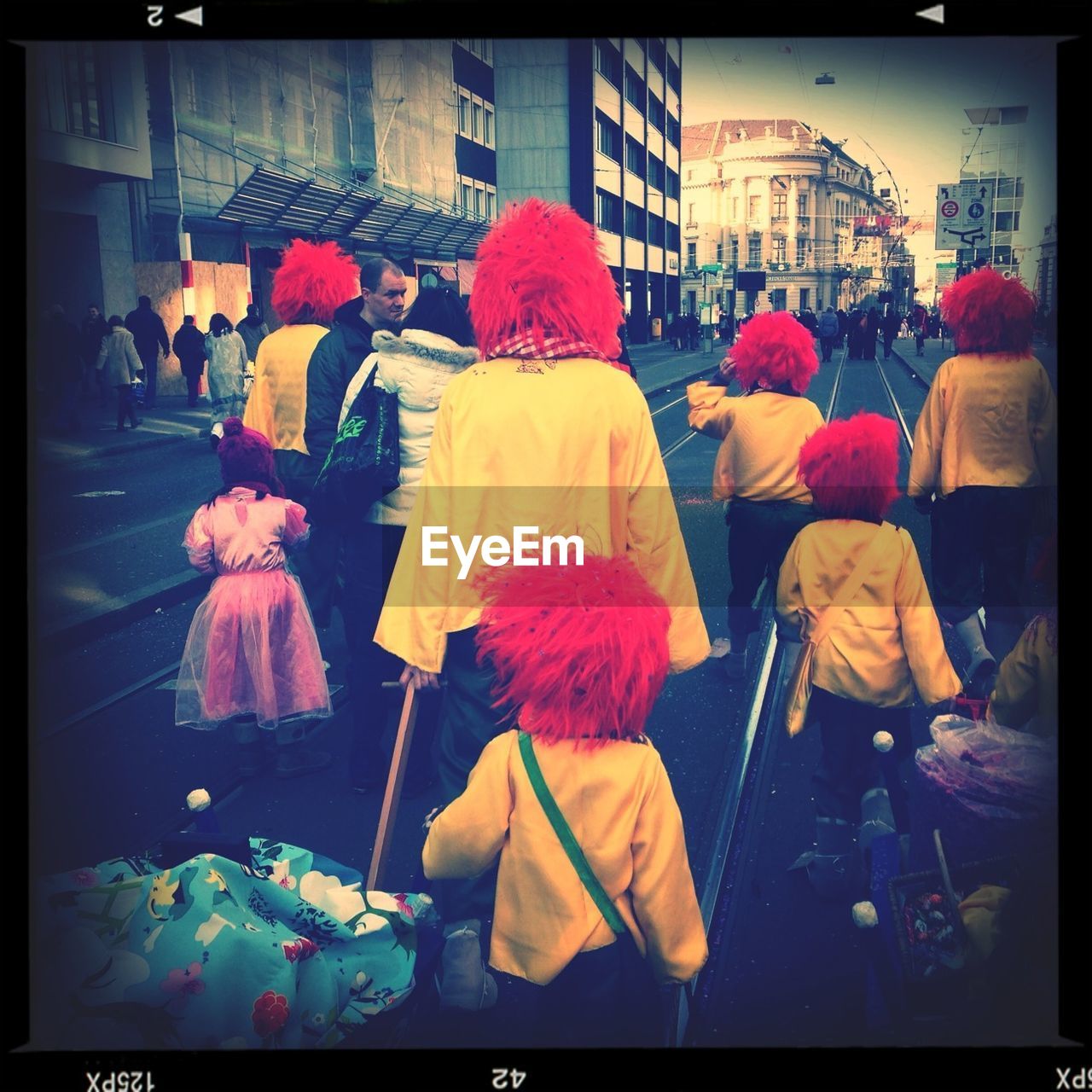 Rear view of people in costume walking on street during carnival