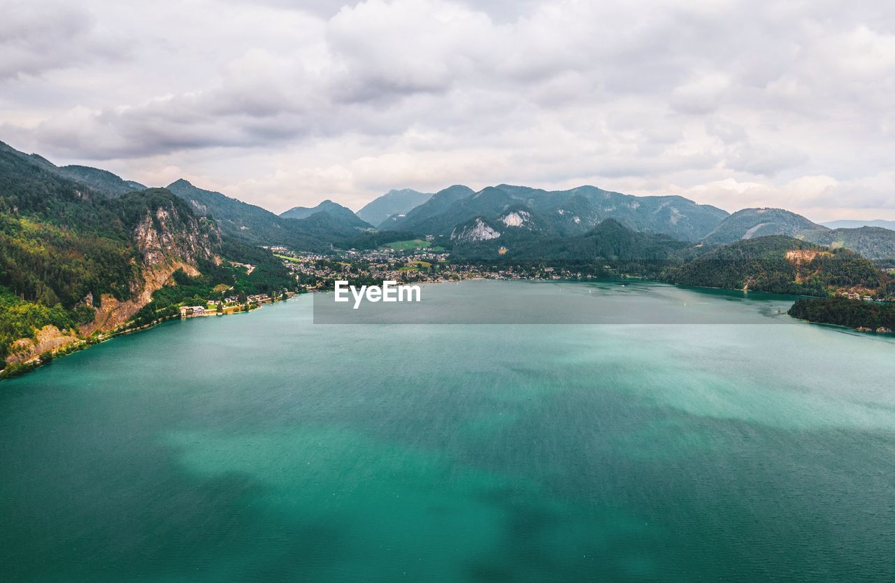 Scenic view of lake by mountains against sky