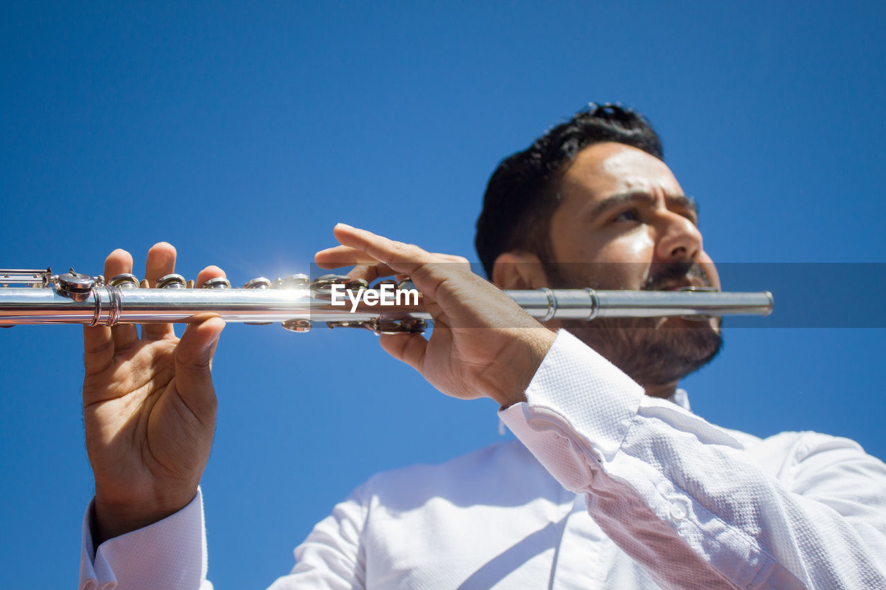 Flautist player and blue sky