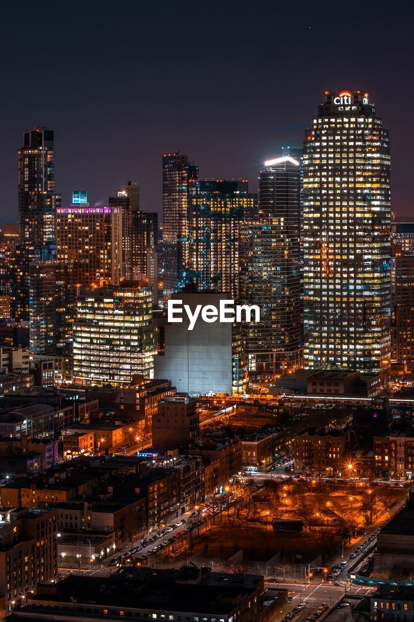 ILLUMINATED MODERN BUILDINGS IN CITY AT NIGHT