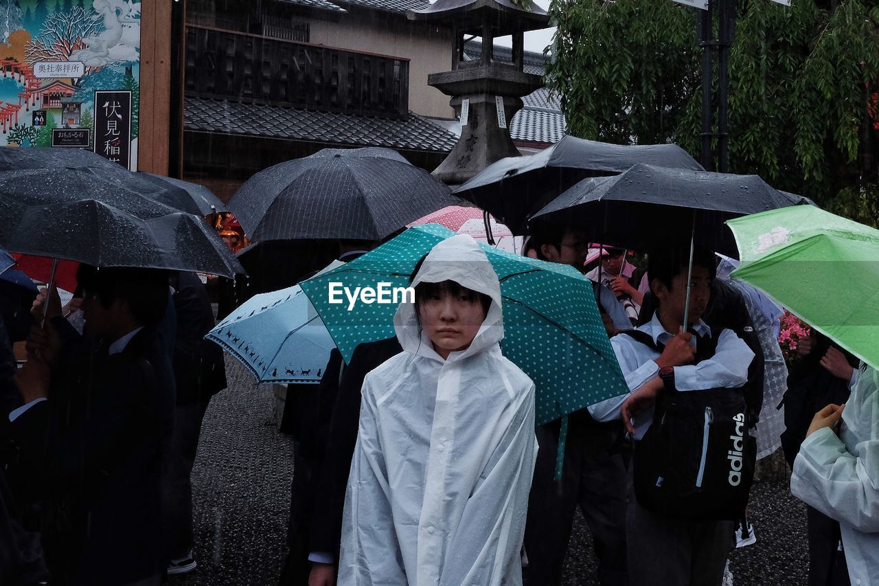 GROUP OF PEOPLE IN RAIN ON RAINY DAY