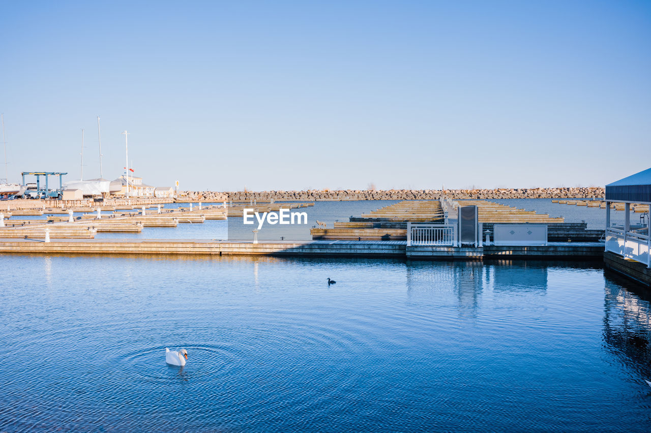 View of bridge over marina against clear blue sky