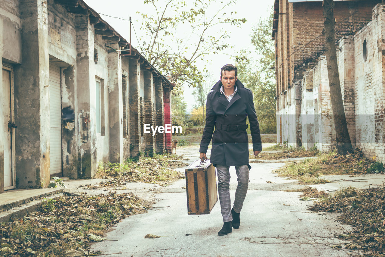 FULL LENGTH PORTRAIT OF A MAN WALKING ON STREET